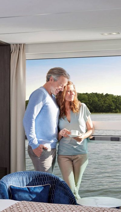 Guest Experience Onboard AMADEUS Riva Cabin Couple Enjoying Coffee In Front Of Panoramic Window In Cabin Of AMADEUS Riva Lueftner Cruises Amadeus Tom Yasny